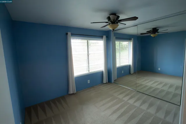 a view of empty room with a ceiling fan and window