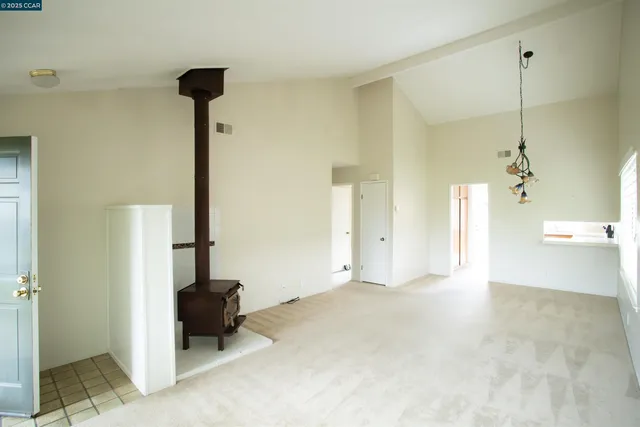 a view of an empty room and a kitchen