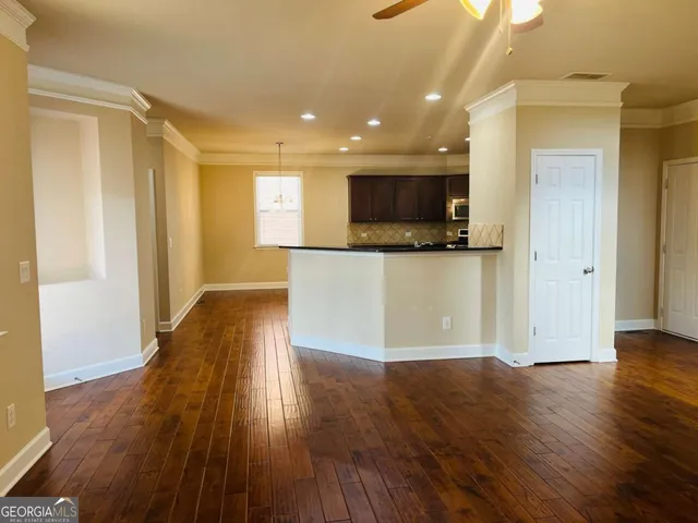 a view of a kitchen with wooden floor and a microwave