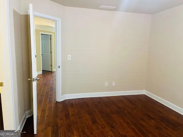an empty room with wooden floor and closet