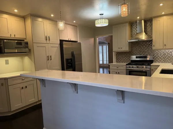 a kitchen with stainless steel appliances a sink a stove a refrigerator and cabinets