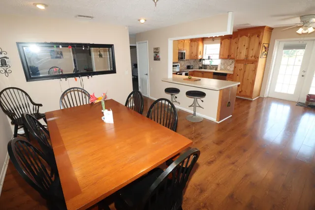 a room with stainless steel appliances furniture a kitchen island wooden floor and a window