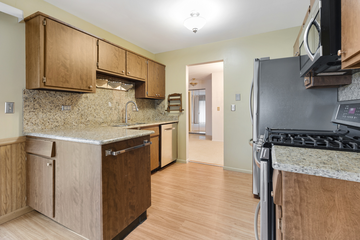 375 Pinetree Lane, Unit D1 Schaumburg, IL 60193 - Photo 11 of 25 a kitchen with stainless steel appliances granite countertop a sink stove and refrigerator