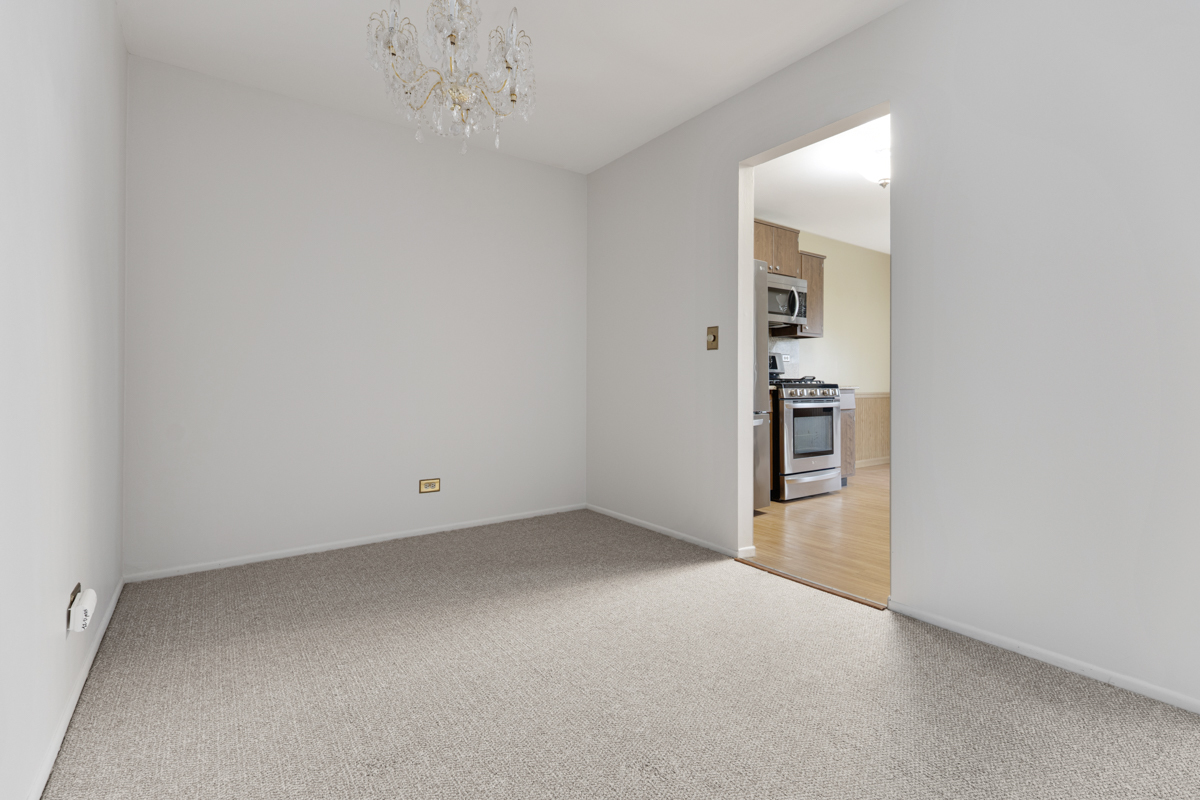 375 Pinetree Lane, Unit D1 Schaumburg, IL 60193 - Photo 5 of 25 an empty room with chandelier fan