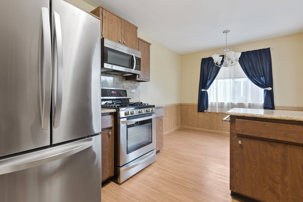 375 Pinetree Lane, Unit D1 Schaumburg, IL 60193 - Photo 8 of 25 a kitchen with kitchen island wooden floor granite counter tops and appliances