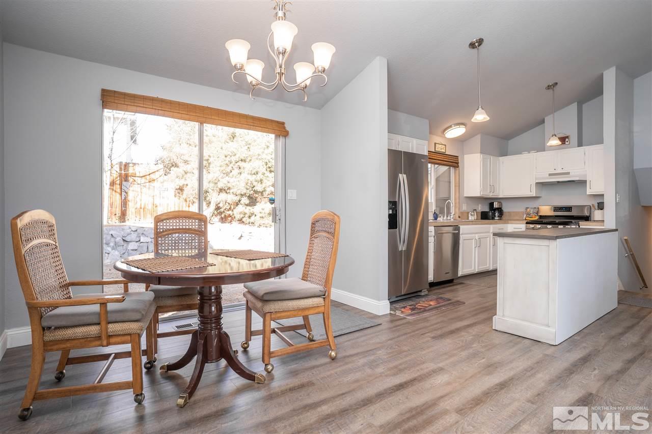 3675 Renee Way Reno, NV 89503 - Photo 16 of 40 a view of a dining room with furniture a chandelier and wooden floor
