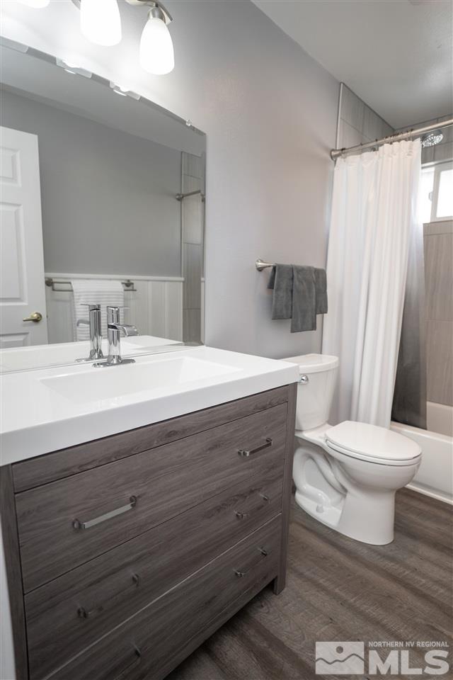 3675 Renee Way Reno, NV 89503 - Photo 30 of 40 a bathroom with a sink a toilet a mirror and shower curtain
