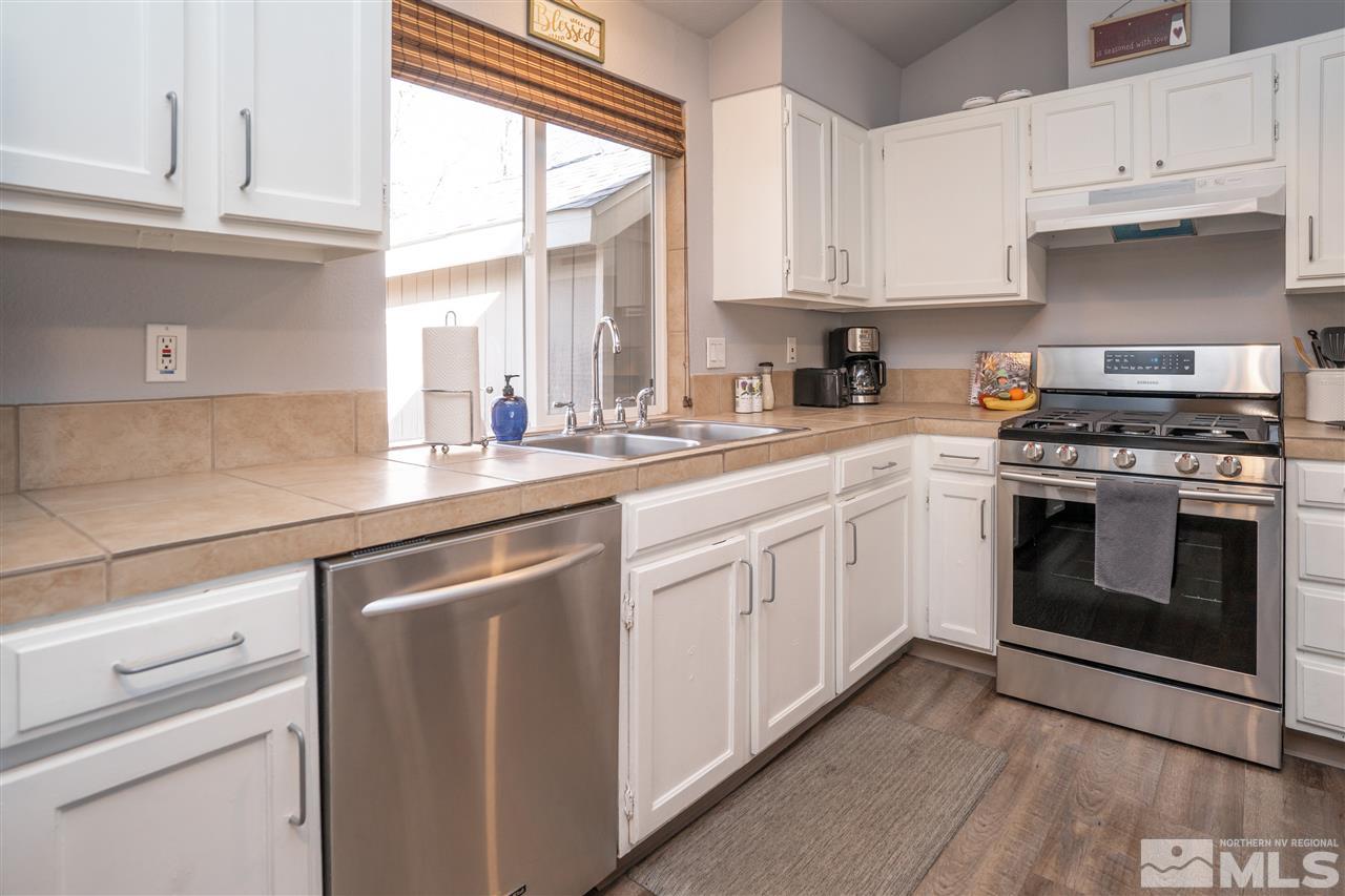 3675 Renee Way Reno, NV 89503 - Photo 3 of 40 a kitchen with granite countertop white cabinets and white stainless steel appliances