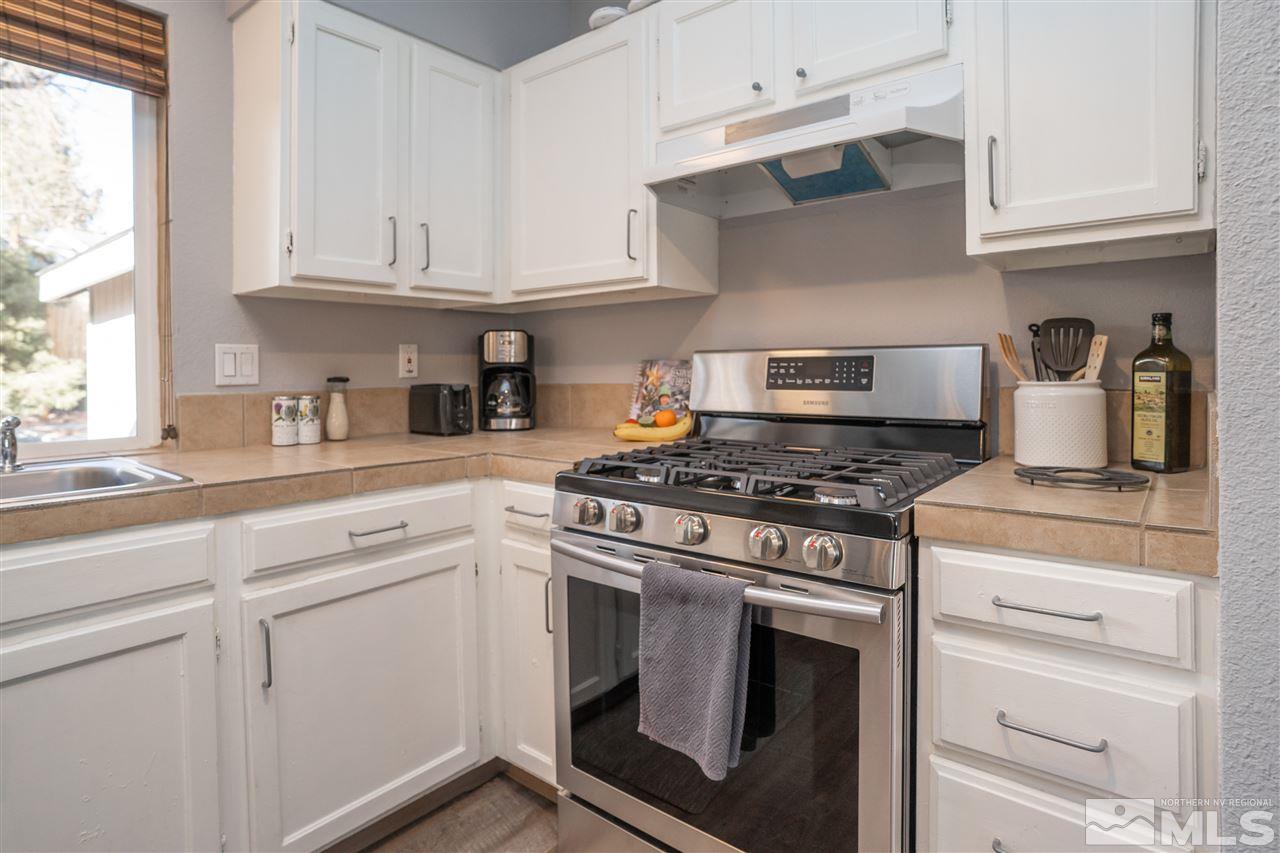 3675 Renee Way Reno, NV 89503 - Photo 6 of 40 a kitchen with granite countertop white cabinets and appliances