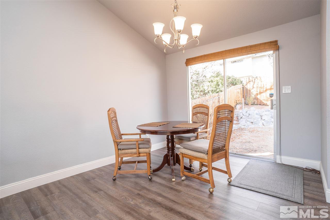 3675 Renee Way Reno, NV 89503 - Photo 7 of 40 a dining room with wooden floor a chandelier a glass table and chairs