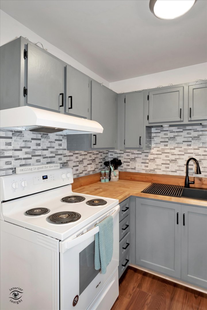 2000 Light Road, Unit 105 Oswego, IL 60543 - Photo 11 of 25 a kitchen with granite countertop a sink a stove and cabinets