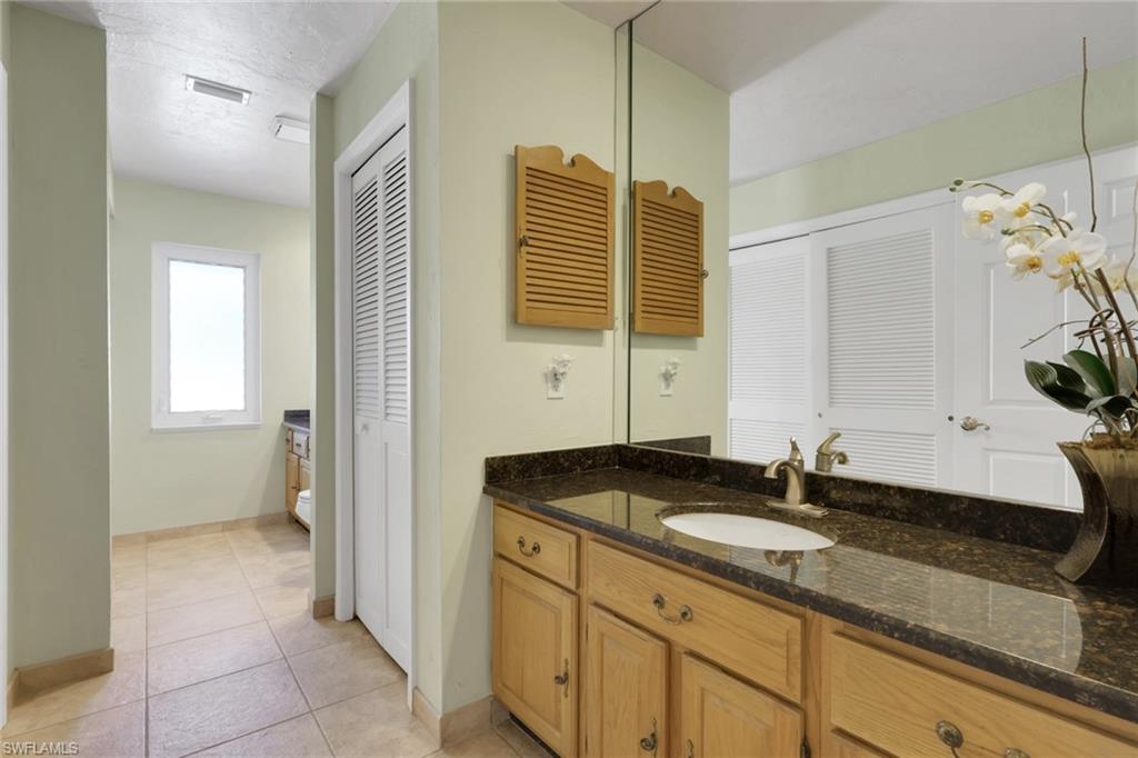 132 Johnnycake Drive Naples, FL 34110 - Photo 17 of 34 a bathroom with a granite countertop sink and a mirror