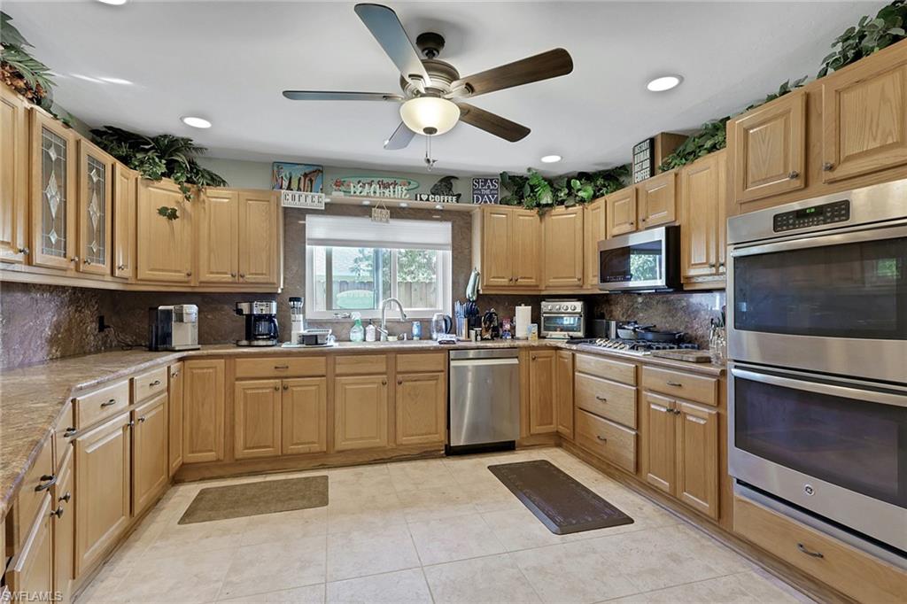 132 Johnnycake Drive Naples, FL 34110 - Photo 5 of 34 a kitchen with granite countertop a sink stainless steel appliances and cabinets