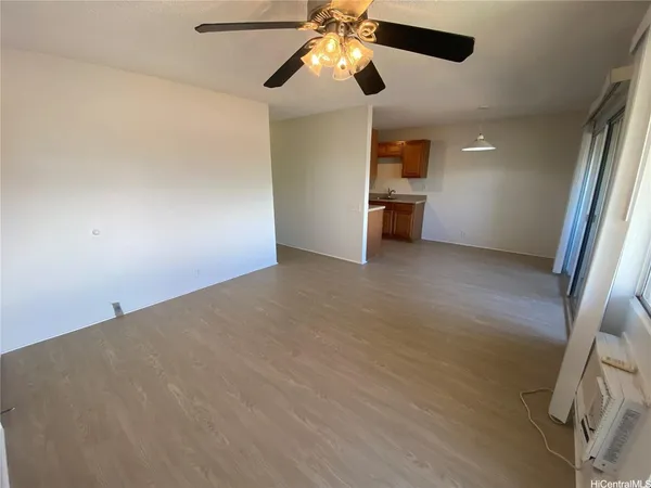 an empty room with windows and fan