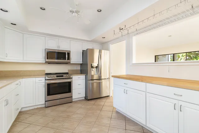 a kitchen with cabinets stainless steel appliances and a window