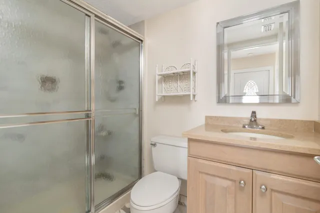 a bathroom with a granite countertop sink toilet and shower