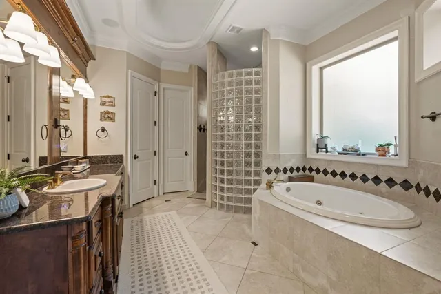 a spacious bathroom with a tub sink shower and mirror