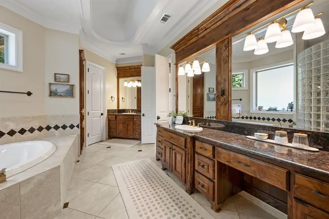 a large bathroom with double vanity sinks a large mirror and a shower