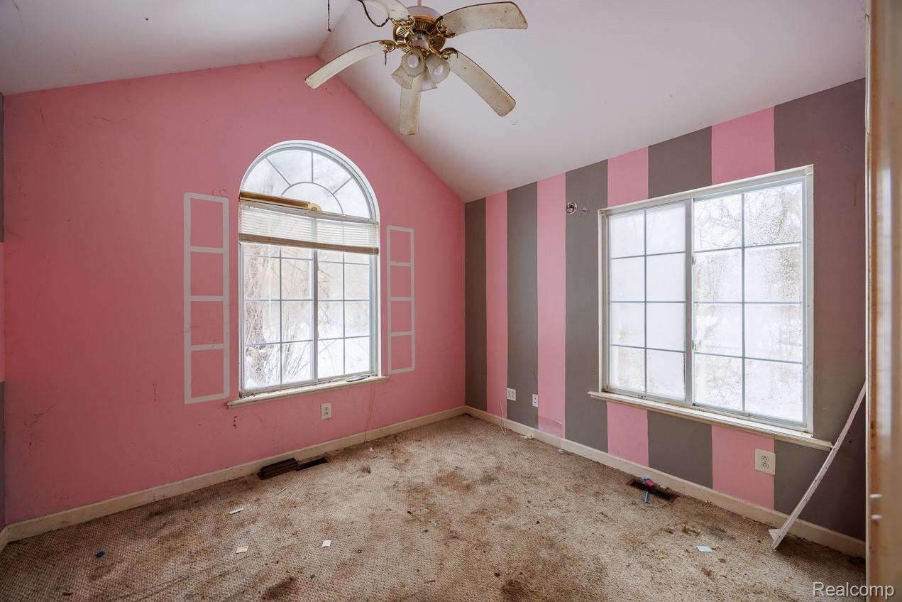 4394 North Center Road Flint, MI 48506 - Photo 6 of 13 Carpeted empty room featuring vaulted ceiling and a ceiling fan