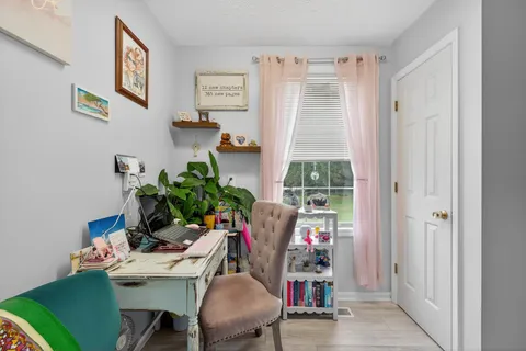 a view of a workspace with furniture and a window