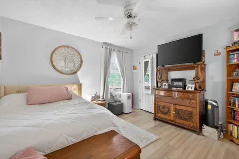 a bedroom with a bed and a flat tv screen on the dresser