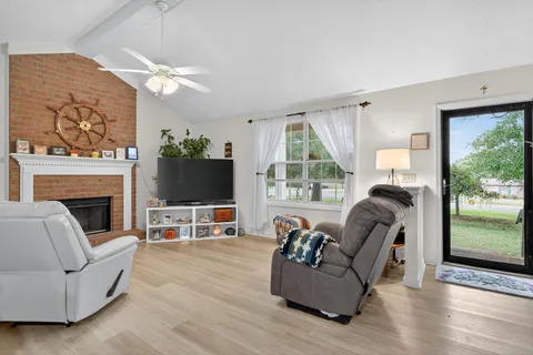 a living room with furniture a flat screen tv and a fireplace