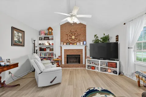 a living room with furniture a flat screen tv and a fireplace