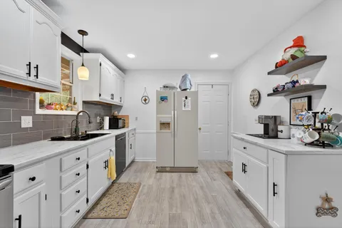 a kitchen with granite countertop a white stove top oven sink and cabinets