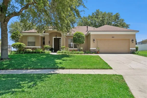 a front view of a house with a yard and trees