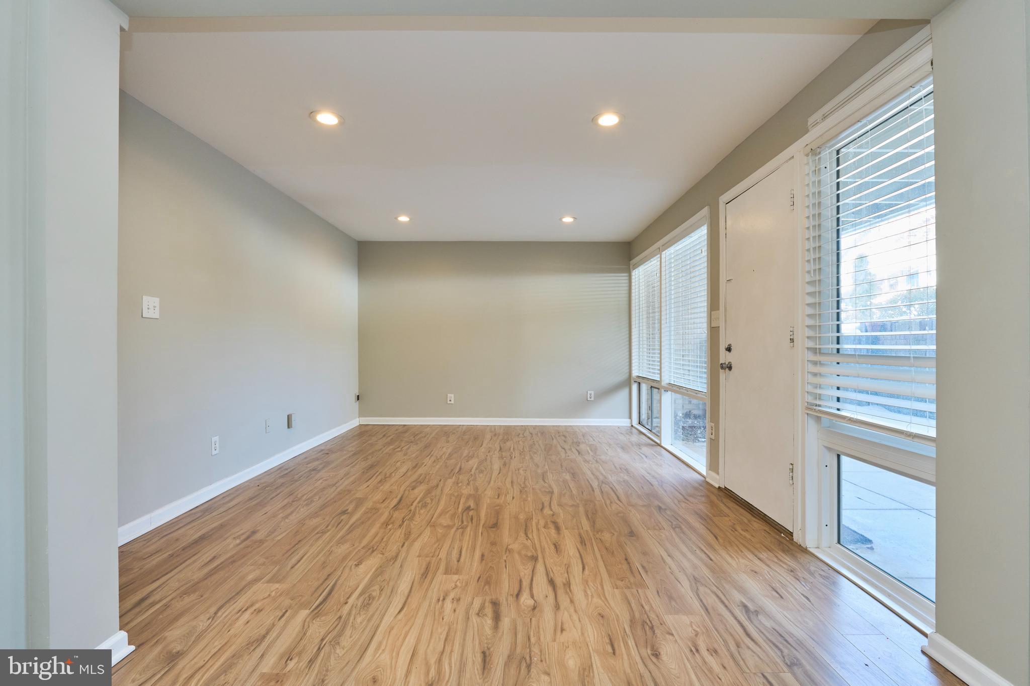 156 Haycock Road, Unit A6 Falls Church, VA 22046 - Photo 11 of 32 a view of an empty room with wooden floor and a window