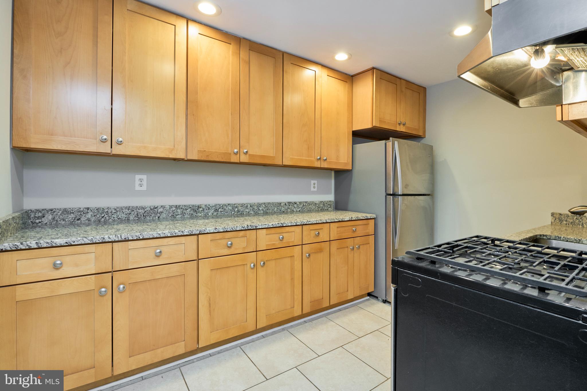 156 Haycock Road, Unit A6 Falls Church, VA 22046 - Photo 12 of 32 a kitchen with stainless steel appliances granite countertop a refrigerator a sink and a stove