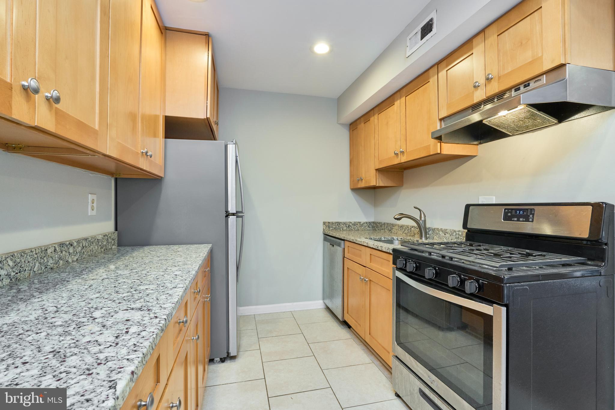 156 Haycock Road, Unit A6 Falls Church, VA 22046 - Photo 14 of 32 a kitchen with stainless steel appliances granite countertop a stove a sink and a microwave