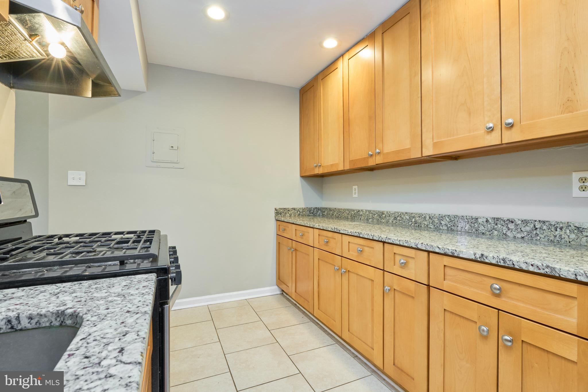 156 Haycock Road, Unit A6 Falls Church, VA 22046 - Photo 16 of 32 a kitchen with granite countertop white cabinets and stainless steel appliances