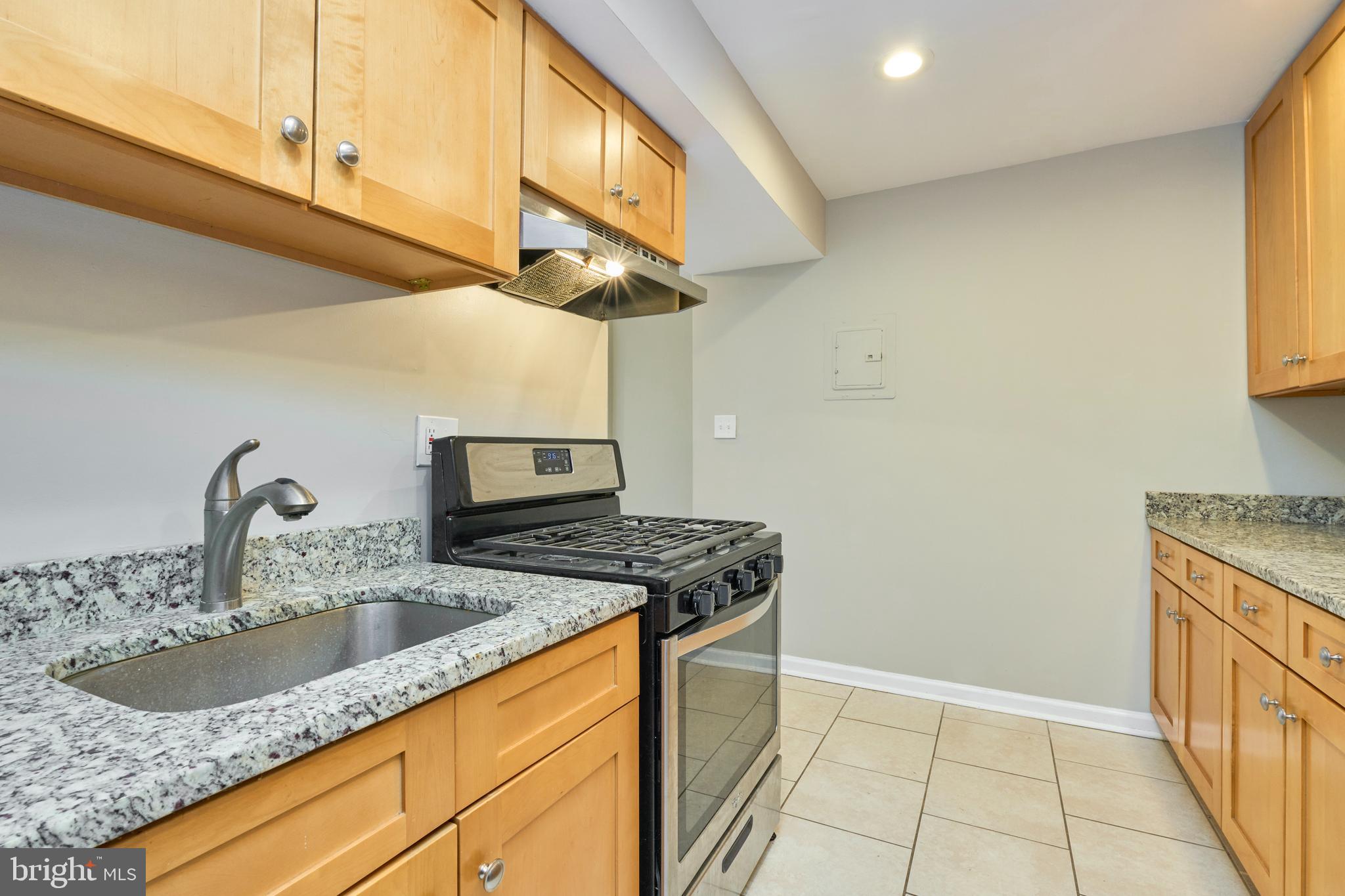 156 Haycock Road, Unit A6 Falls Church, VA 22046 - Photo 17 of 32 a kitchen with granite countertop a sink a stove and cabinets