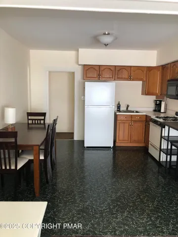 a kitchen with granite countertop a sink stove and refrigerator