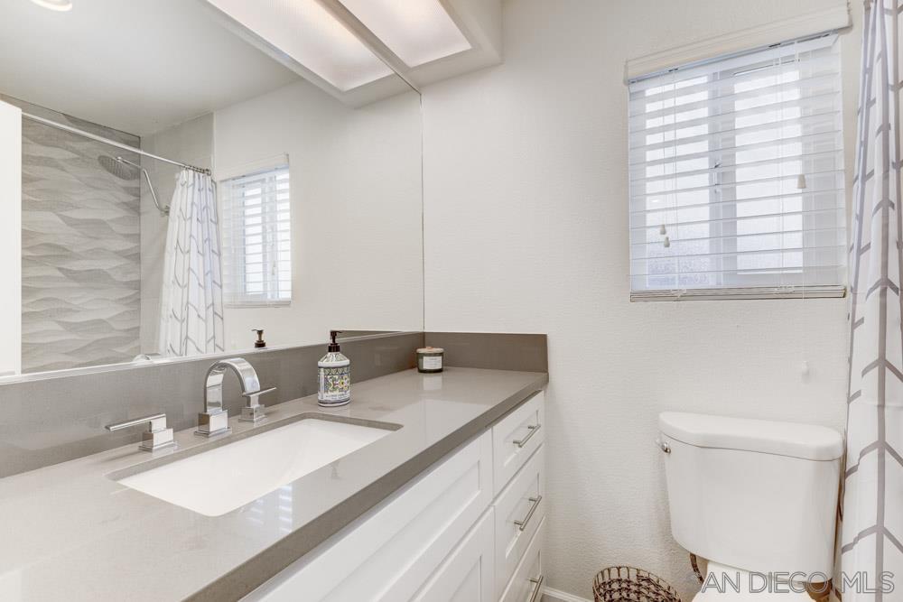 807 Highland Drive Solana Beach, CA 92075 - Photo 24 of 27 a bathroom with a granite countertop sink a toilet a mirror and a window
