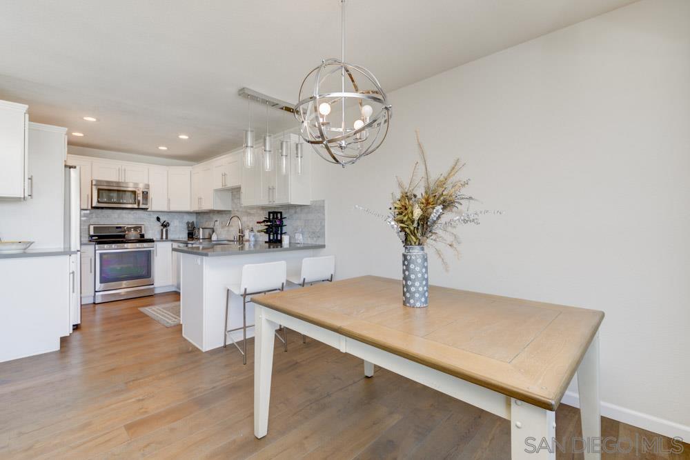 807 Highland Drive Solana Beach, CA 92075 - Photo 7 of 27 a kitchen with kitchen island stainless steel appliances a dining table chairs sink and cabinets