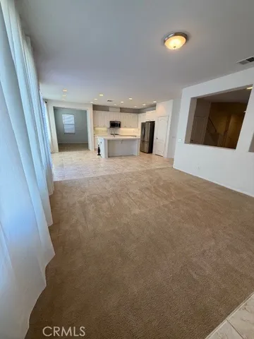 a view of kitchen with refrigerator cabinets and window