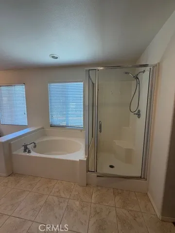 a bathroom with a tub a sink and a large mirror