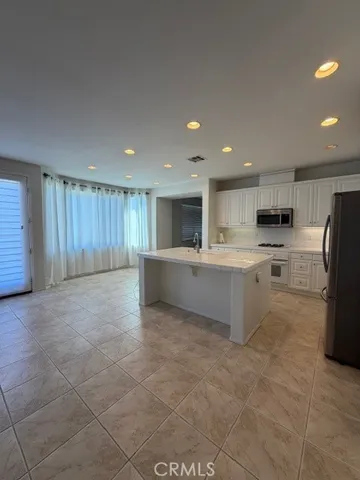 a large kitchen with stainless steel appliances granite countertop a large counter top and a stove top oven