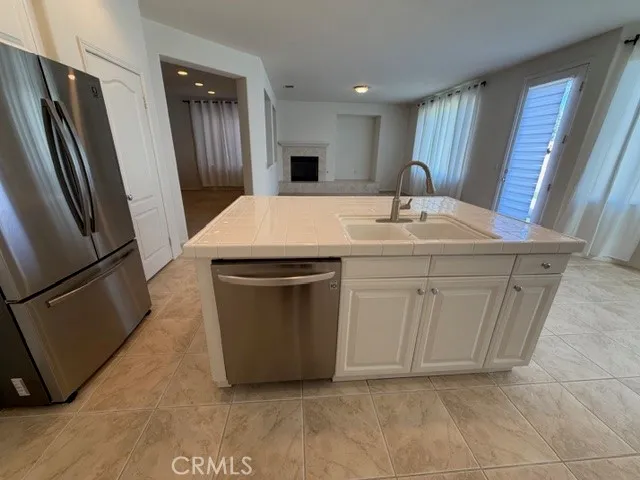 a kitchen with a sink a refrigerator and cabinets