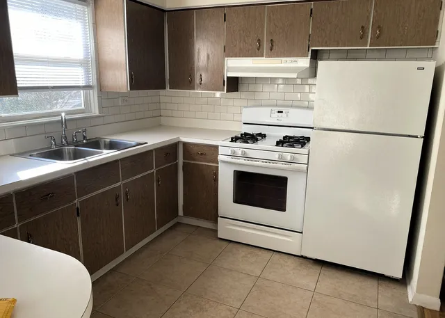 a kitchen with a white stove top oven and sink