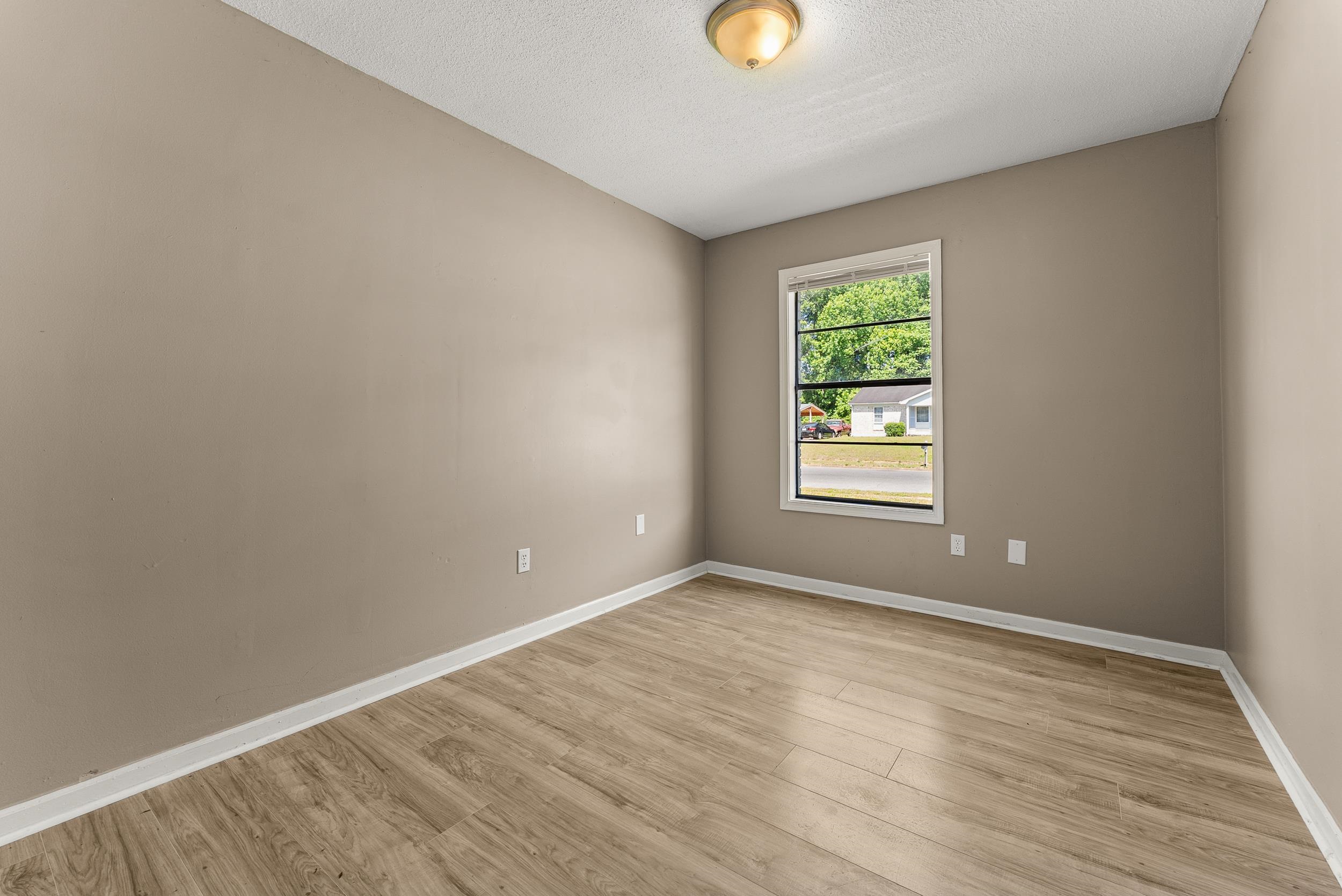 3759 McCain Road Memphis, TN 38109 - Photo 24 of 30 a view of an empty room with wooden floor and a window