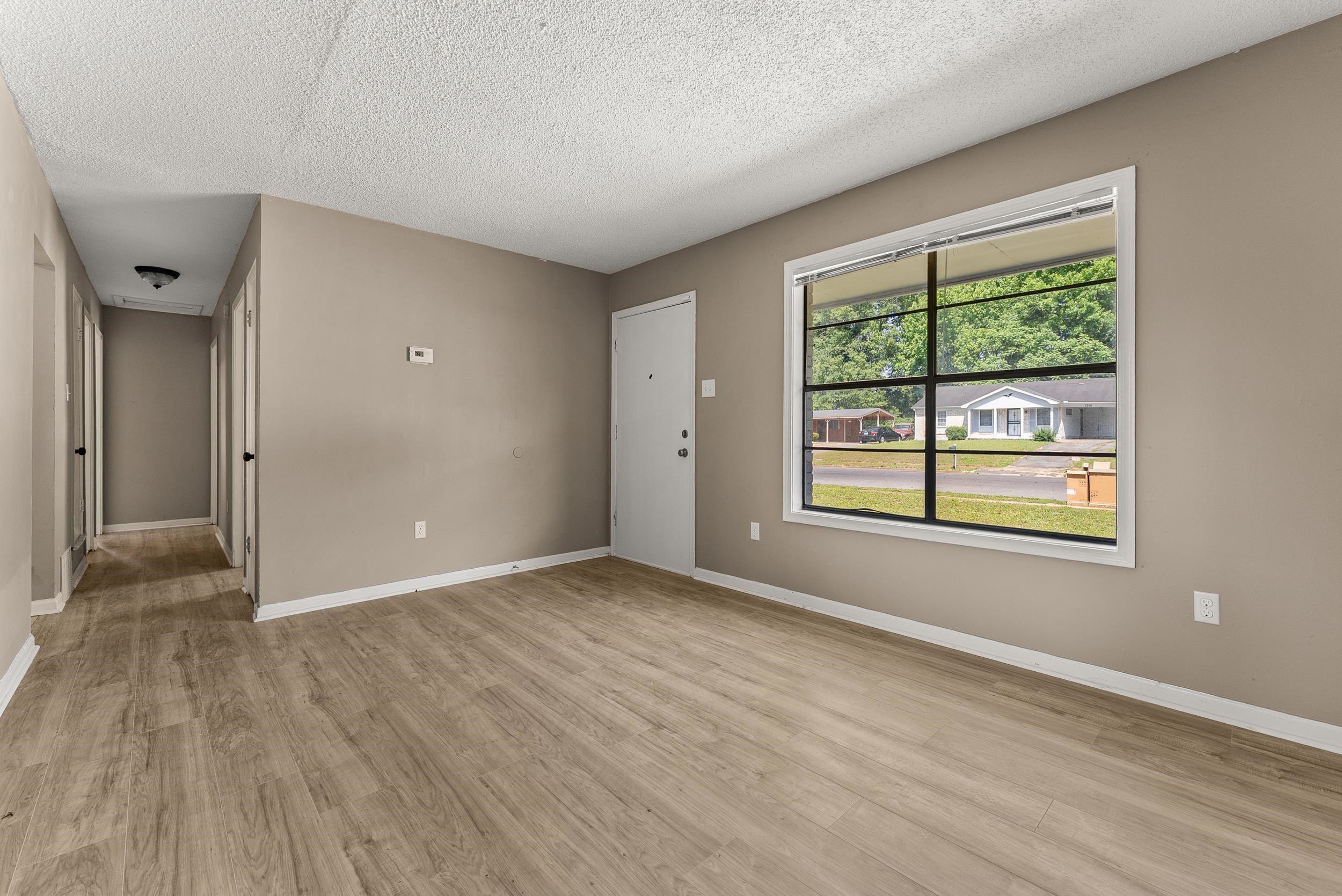 3759 McCain Road Memphis, TN 38109 - Photo 5 of 30 a view of an empty room with wooden floor and a window
