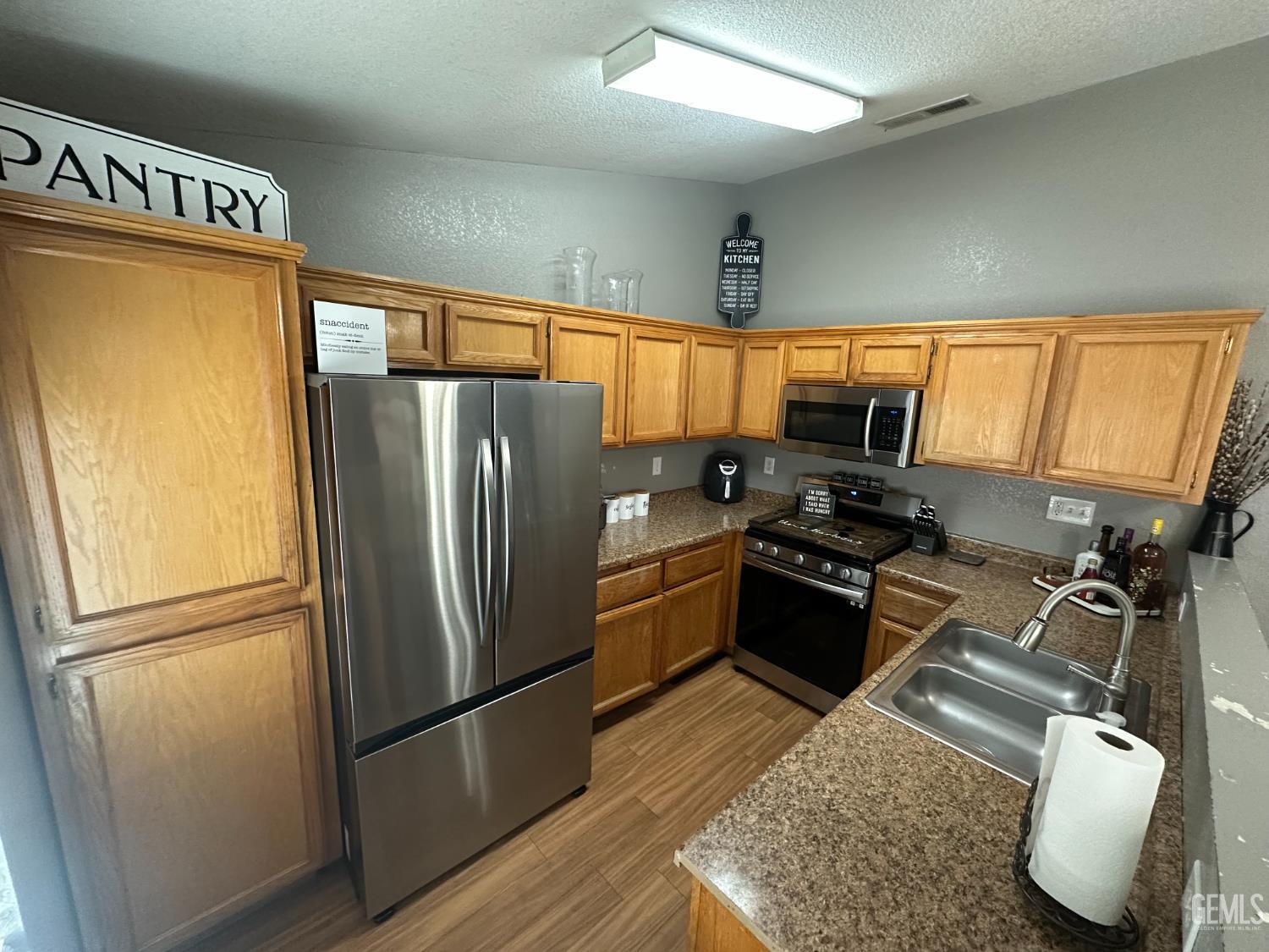 Undisclosed Address Bakersfield, CA 93307 - Photo 12 of 15 a kitchen with granite countertop stainless steel appliances a refrigerator a stove a sink cabinets and a refrigerator