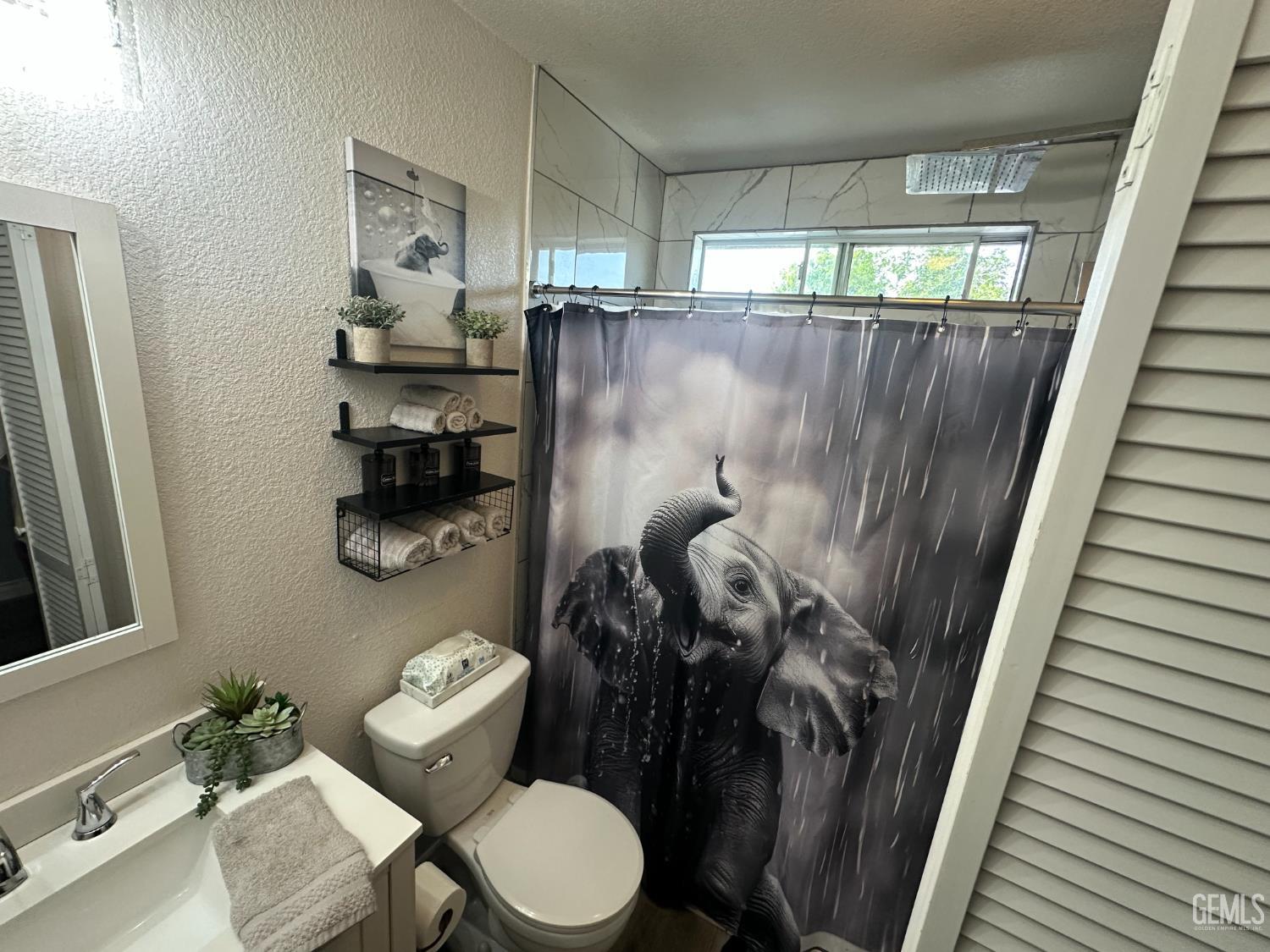 Undisclosed Address Bakersfield, CA 93307 - Photo 7 of 15 a bathroom with a toilet and a shower curtain