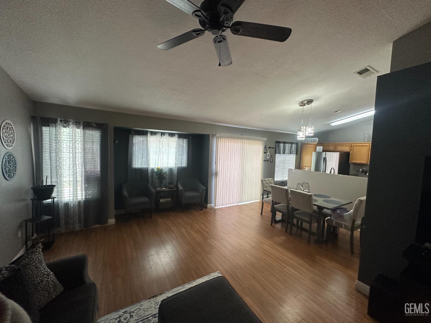 Undisclosed Address Bakersfield, CA 93307 - Photo 10 of 15 a view of a livingroom with furniture hardwood floor and a ceiling fan