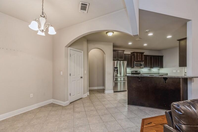 516 Pheasant Trail Crestview, FL 32536 - Photo 14 of 38 a kitchen with stainless steel appliances granite countertop a refrigerator a sink dishwasher a stove and a dining table with wooden floor