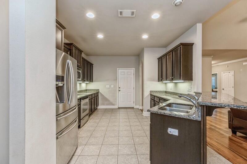 516 Pheasant Trail Crestview, FL 32536 - Photo 17 of 38 a kitchen with granite countertop a refrigerator and a sink