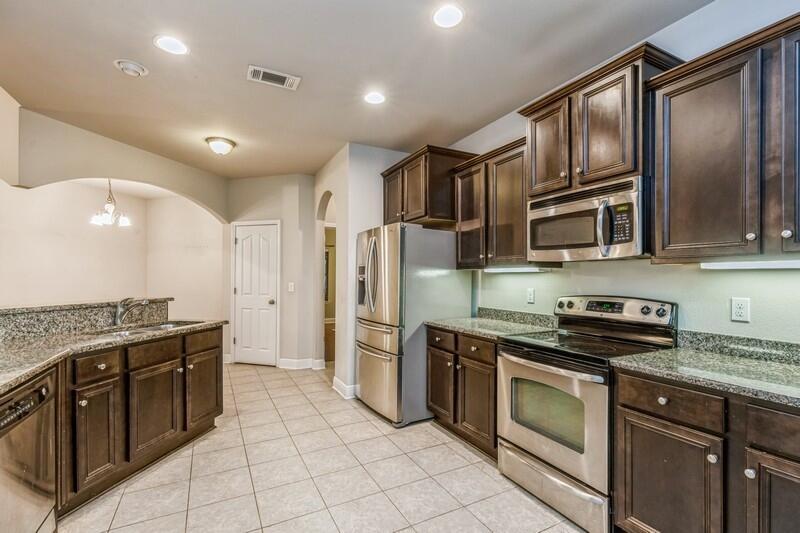 516 Pheasant Trail Crestview, FL 32536 - Photo 20 of 38 a kitchen with stainless steel appliances granite countertop a stove and a refrigerator